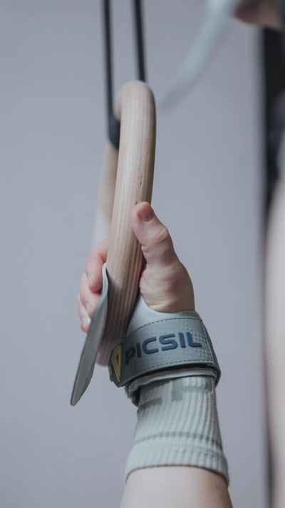 Mano sujetando un aro de gimnasia con ayuda de una callera sin agujeros de Crossfit