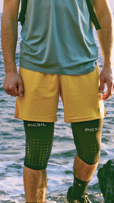 Tren inferior de un hombre con pantalones amarillos, rodilleras y calcetines de de picsil